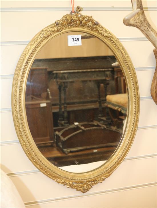 An oval giltwood and gesso framed wall mirror, H.58cm